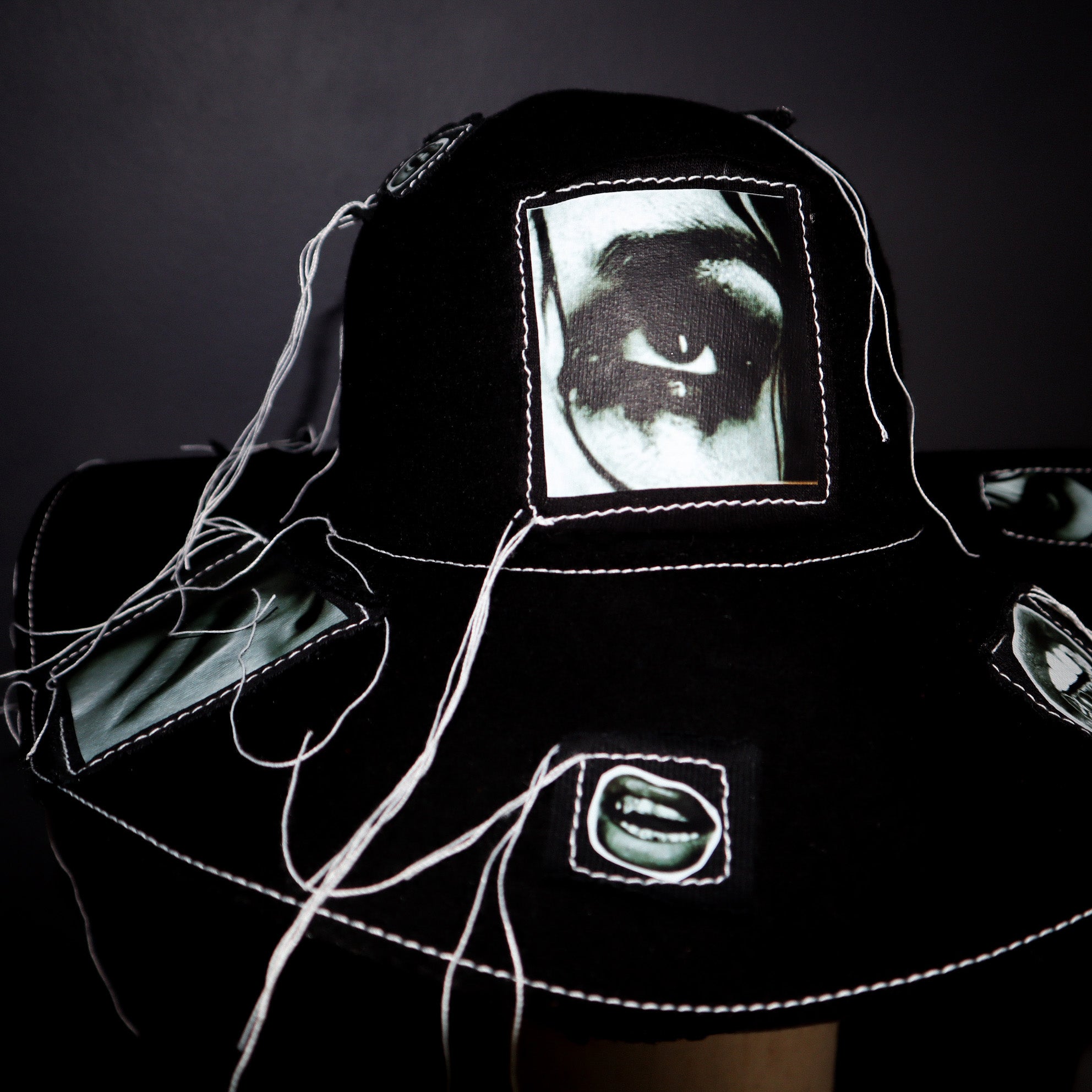 100% WOOL HAT W/ BLACK + WHITE EYE GRAPHICS + TOPSTITCH DETAIL