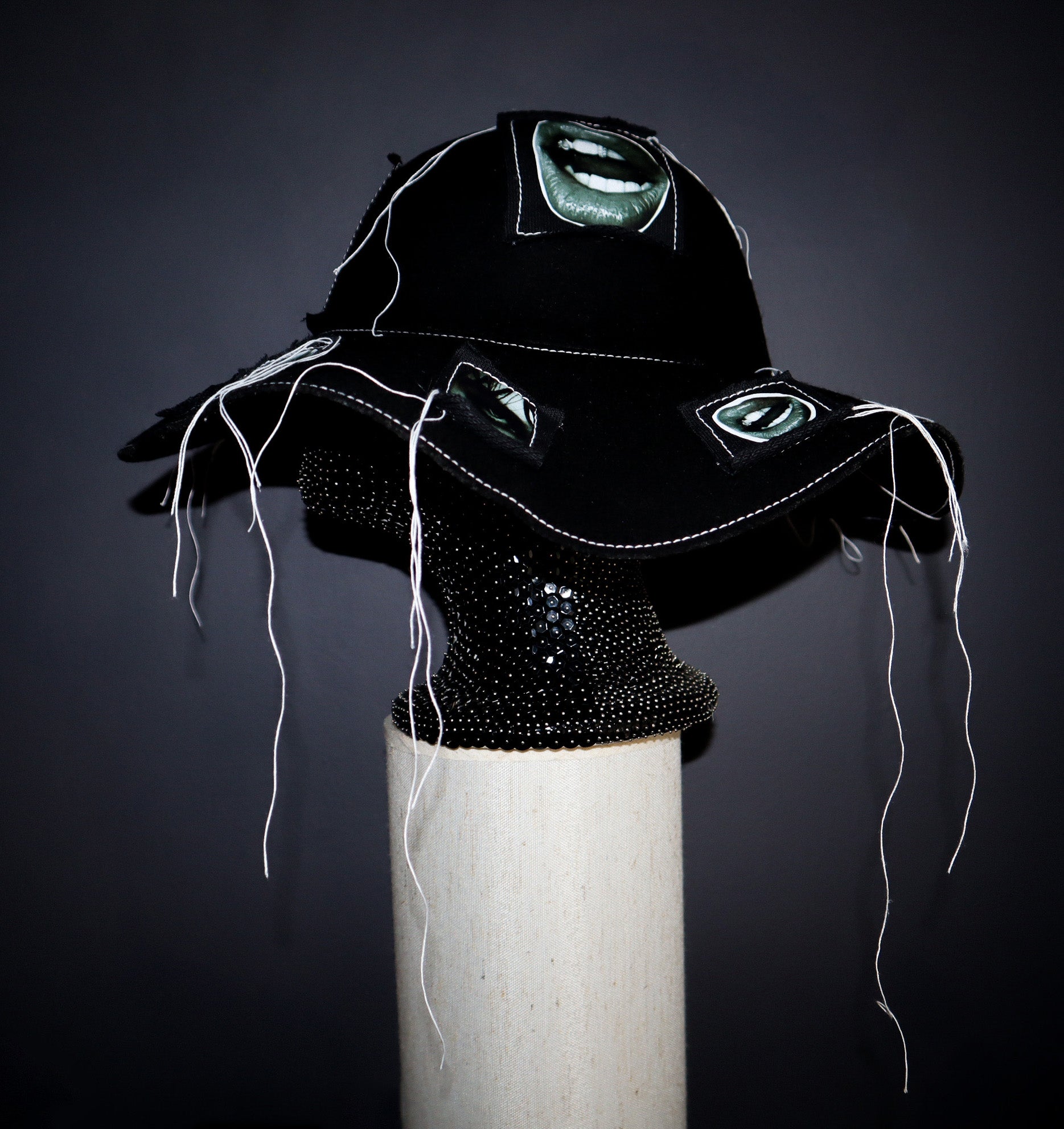 100% WOOL HAT W/ BLACK + WHITE EYE GRAPHICS + TOPSTITCH DETAIL