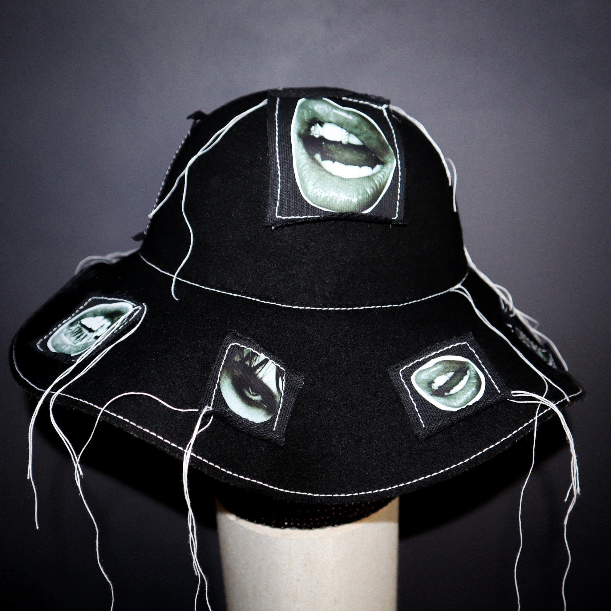 100% WOOL HAT W/ BLACK + WHITE EYE GRAPHICS + TOPSTITCH DETAIL