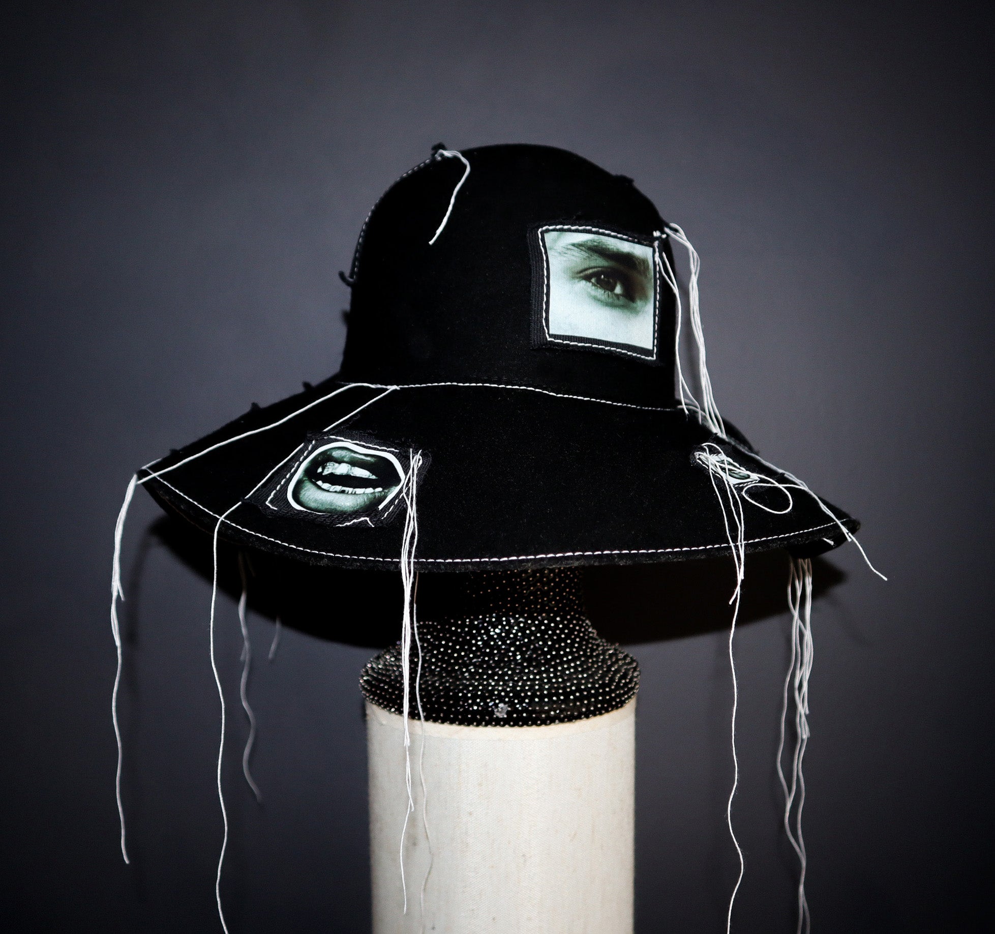 100% WOOL HAT W/ BLACK + WHITE EYE GRAPHICS + TOPSTITCH DETAIL
